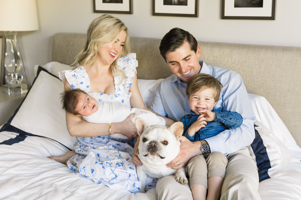 family smiling together with newborn baby