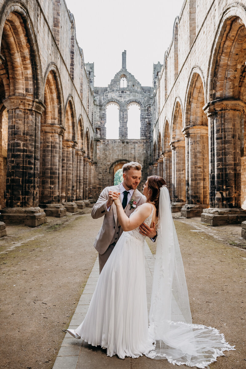 Bride and Groom at Kirkstall Abbey doing dip kiss
