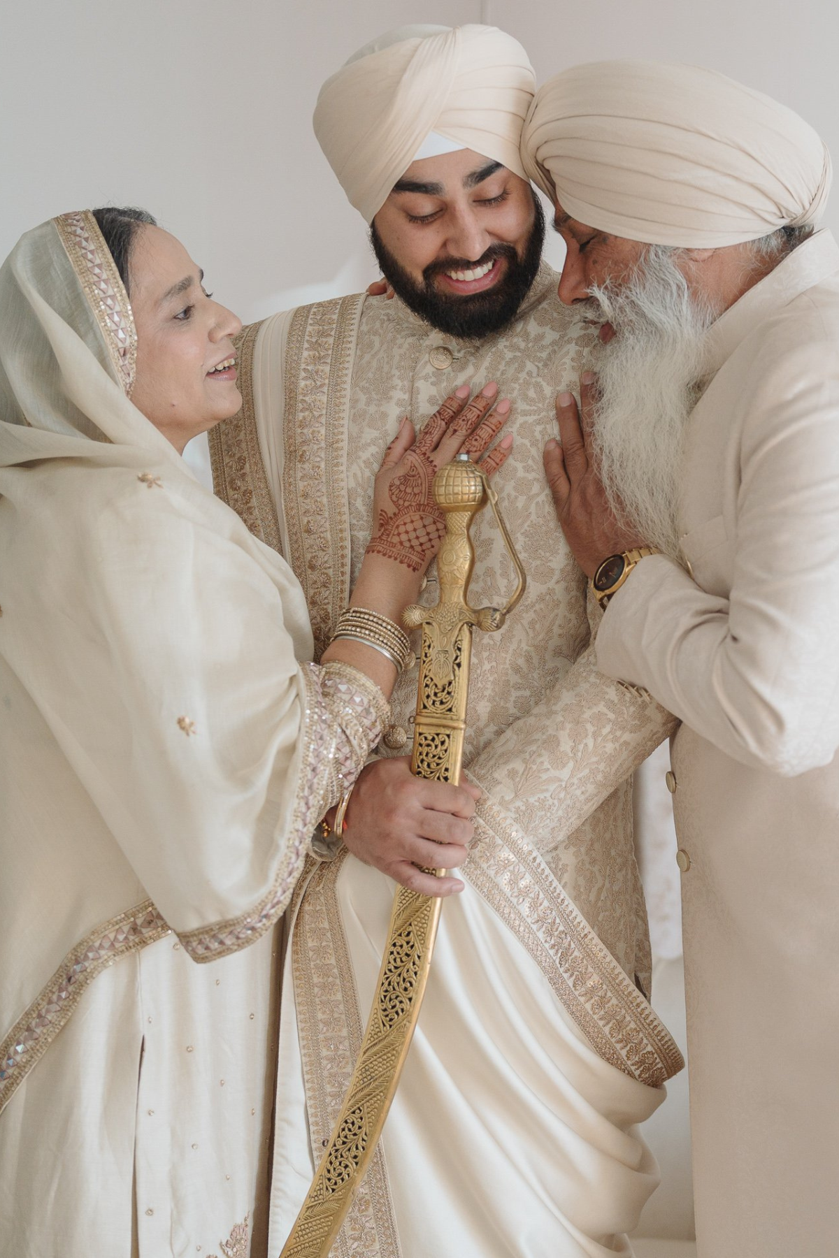 sikh-wedding-outdoor-groom-ivory-sherwani-sword-father-mother-son
