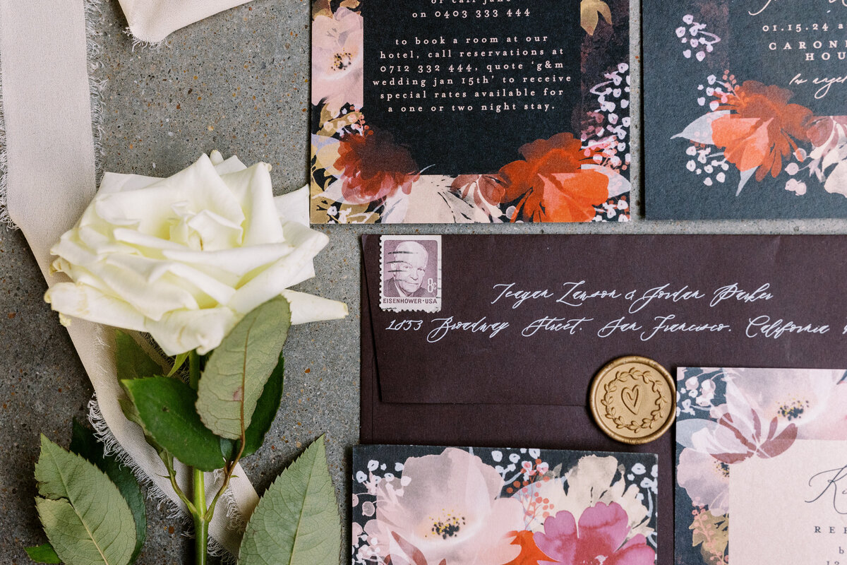 wedding invitation suite flatlay with floral accents