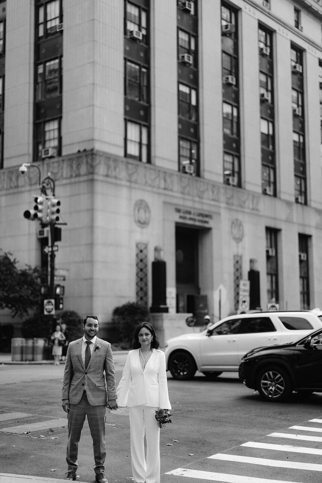 The bride and groom are in the middle of the street, heading over to New York City Hall for their elopement. Image by Jenny Fu Studio