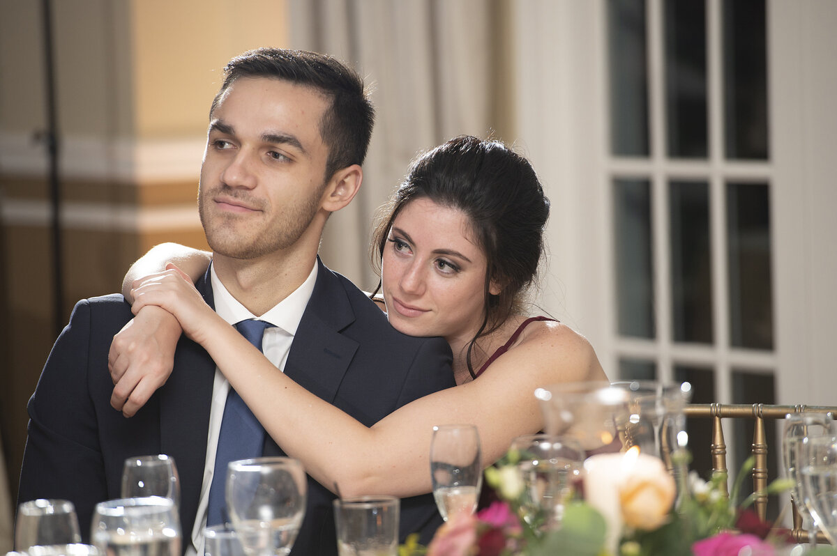 A person sitting down with their arms wrapped around their partner 