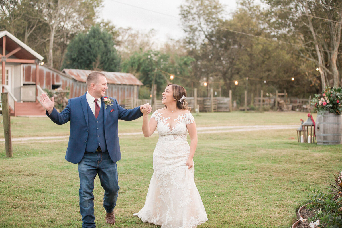 The bride and groom, ready to enter their reception, look at each other and make a celebratory gesture