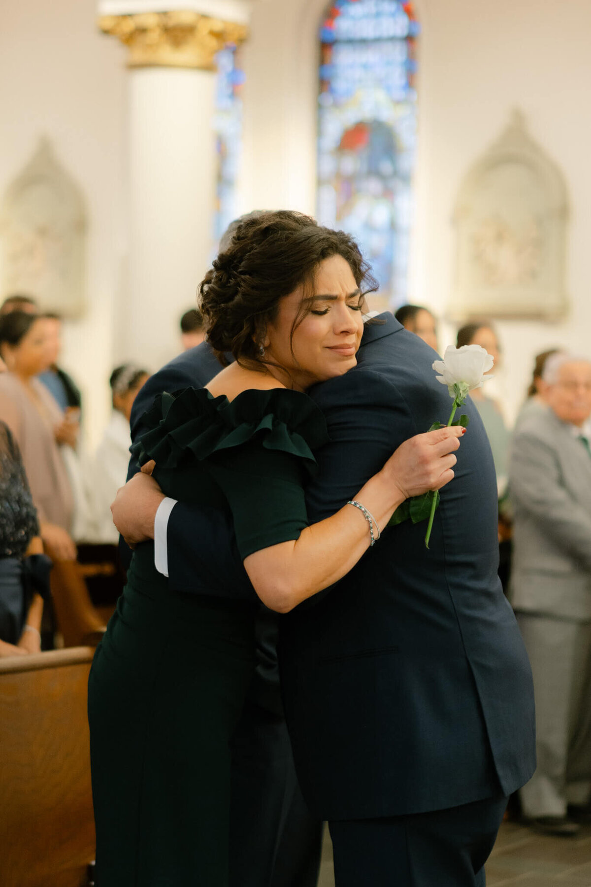 groom and his mom hugging after walking down the isle