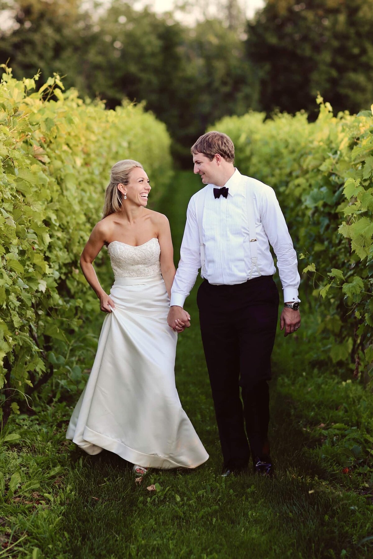 Bride and groom walking in vineyard