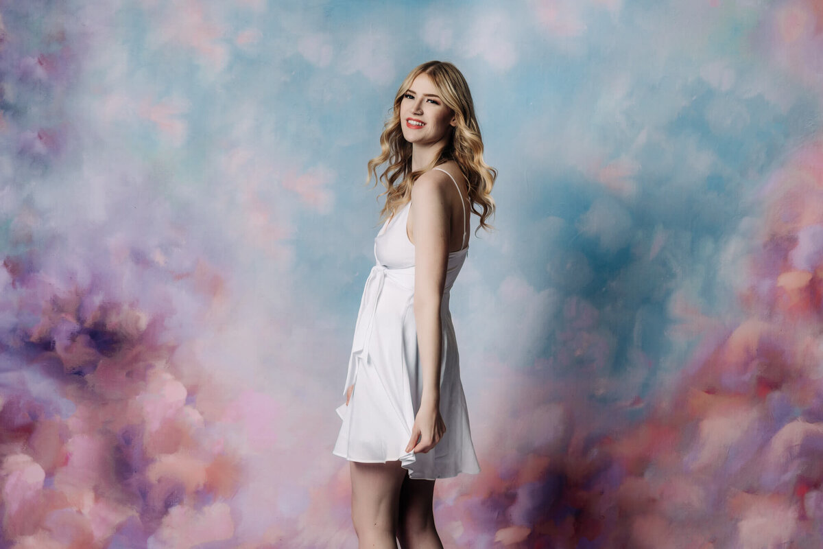 Prescott senior photography session in front of floral wall with ERAU senior.