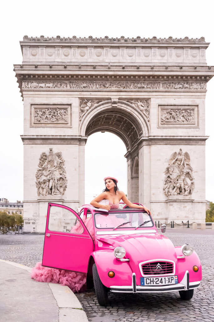 Romantic Paris portrait at Arc de Triomphe - woman in pink dress with matching beret and pink car during luxury photoshoot