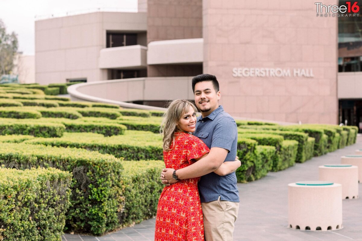 Engaged couple embrace one another during photo shoot