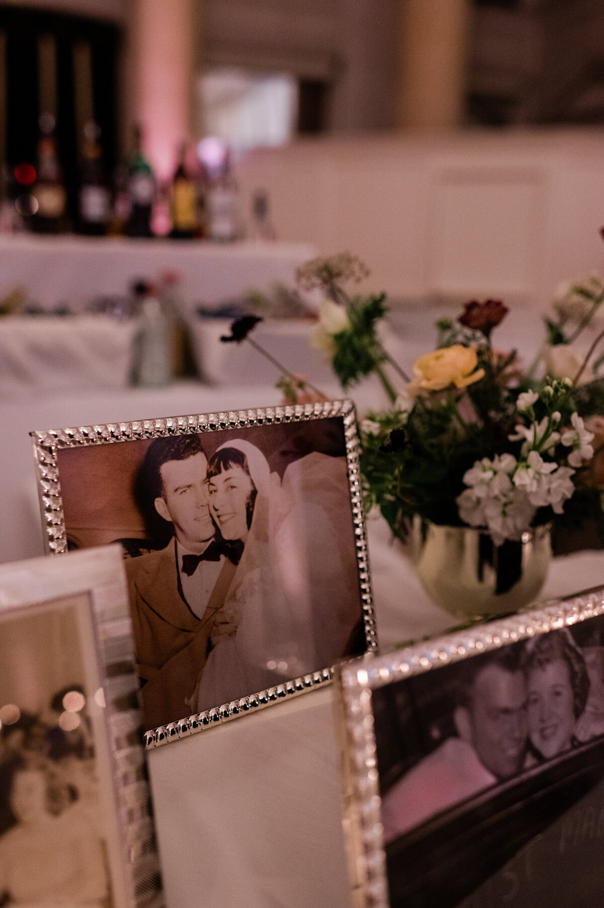 Old photo frames of family members sit on a reception table 