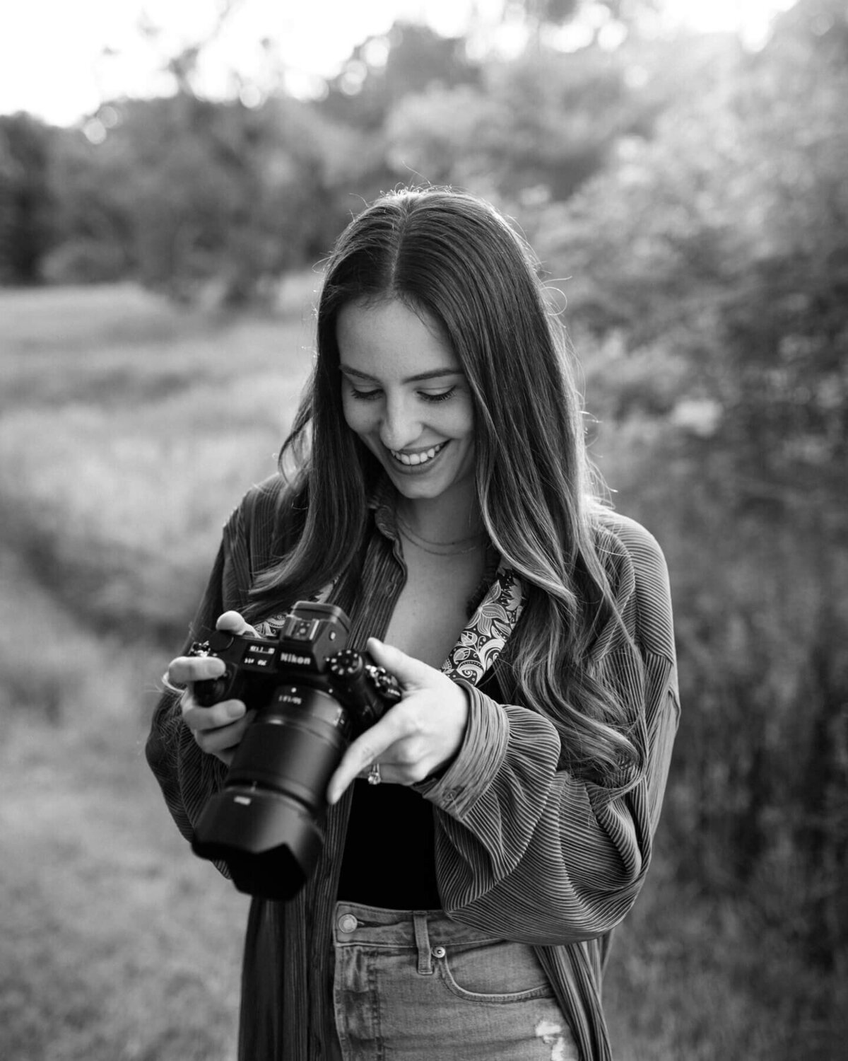 Kim Pickett, a Photographer, looking down at her back of her camera