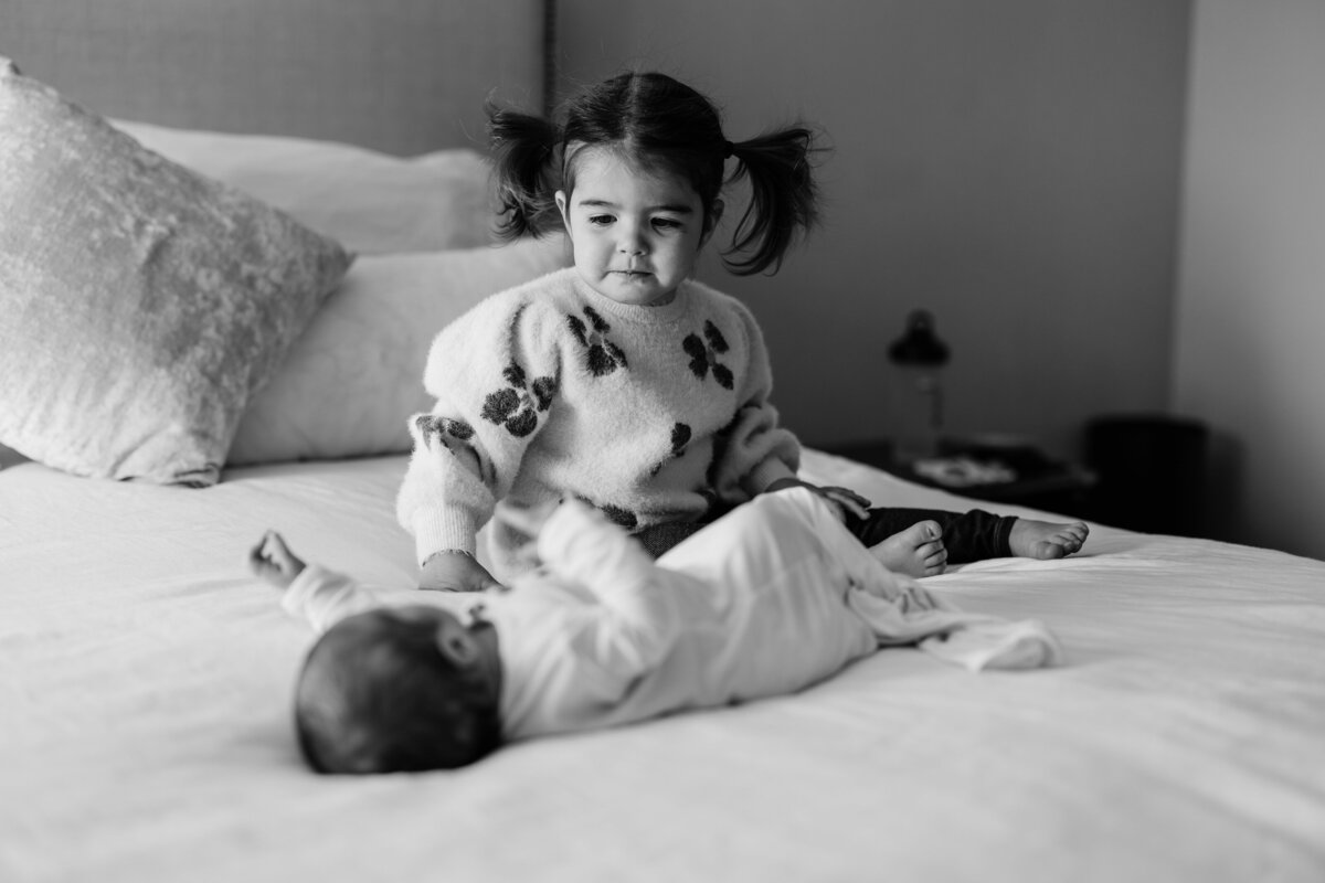 toddler-looking-at-her-baby-sister