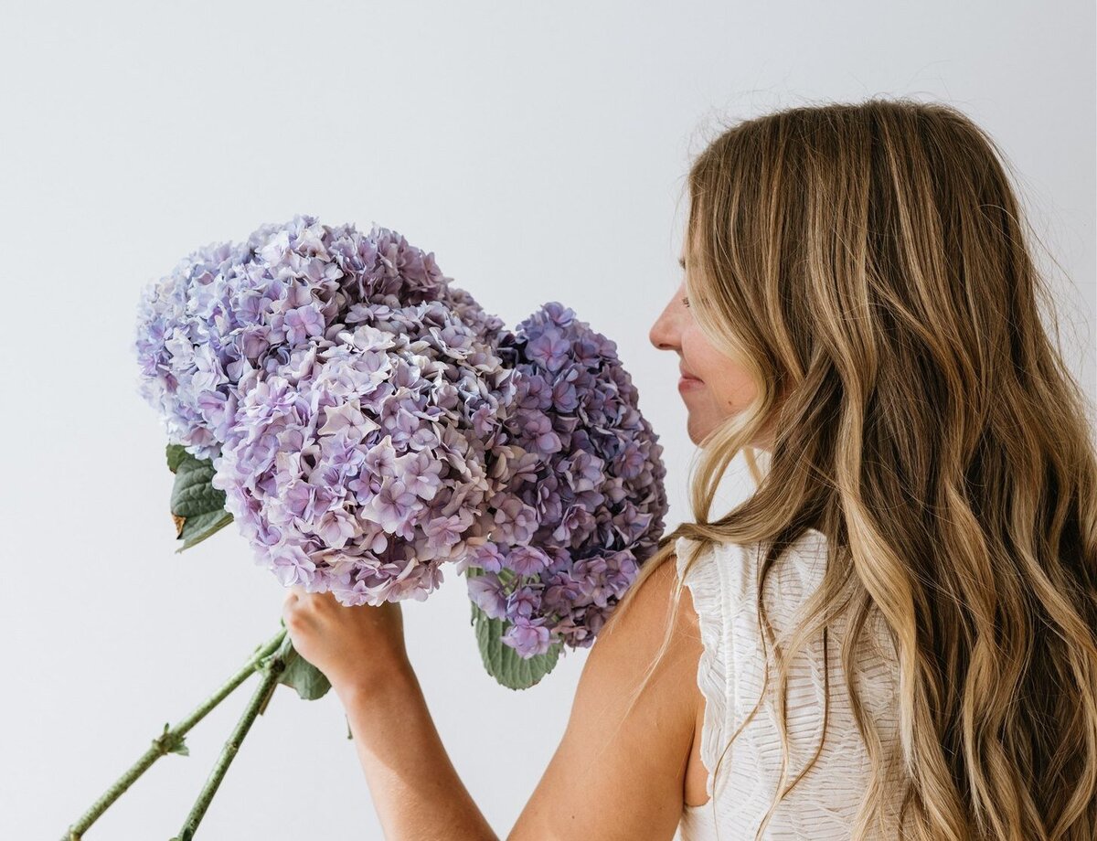 Florist holding a bouquet of purple hydrangeas