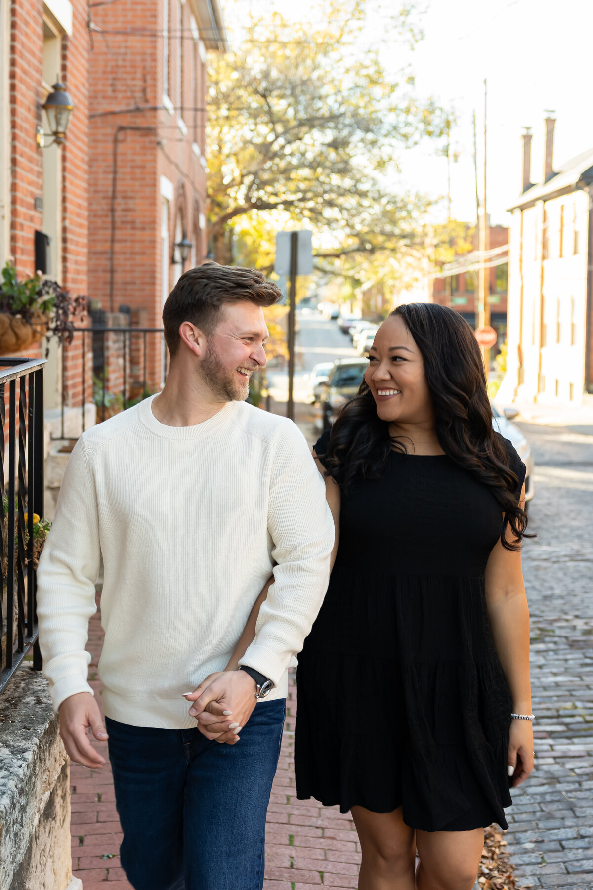 couple laughing and walking hand in hand German Village in Columbus