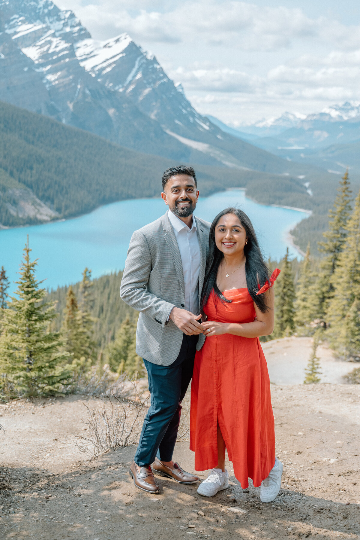 Newly engaged couple smiling for a photograph at Peyto Lake during a photo session.