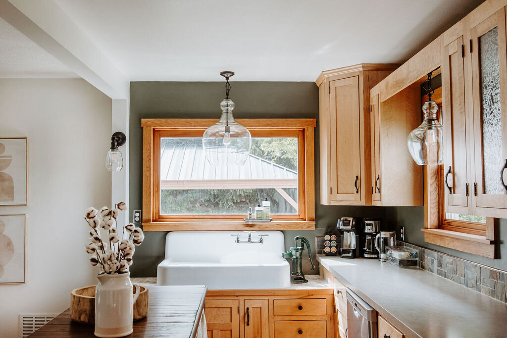 the vintage kitchen in the modern farmhouse overnight accommodations at the Willowbrook wedding venue with dark olive benjamin moore paint