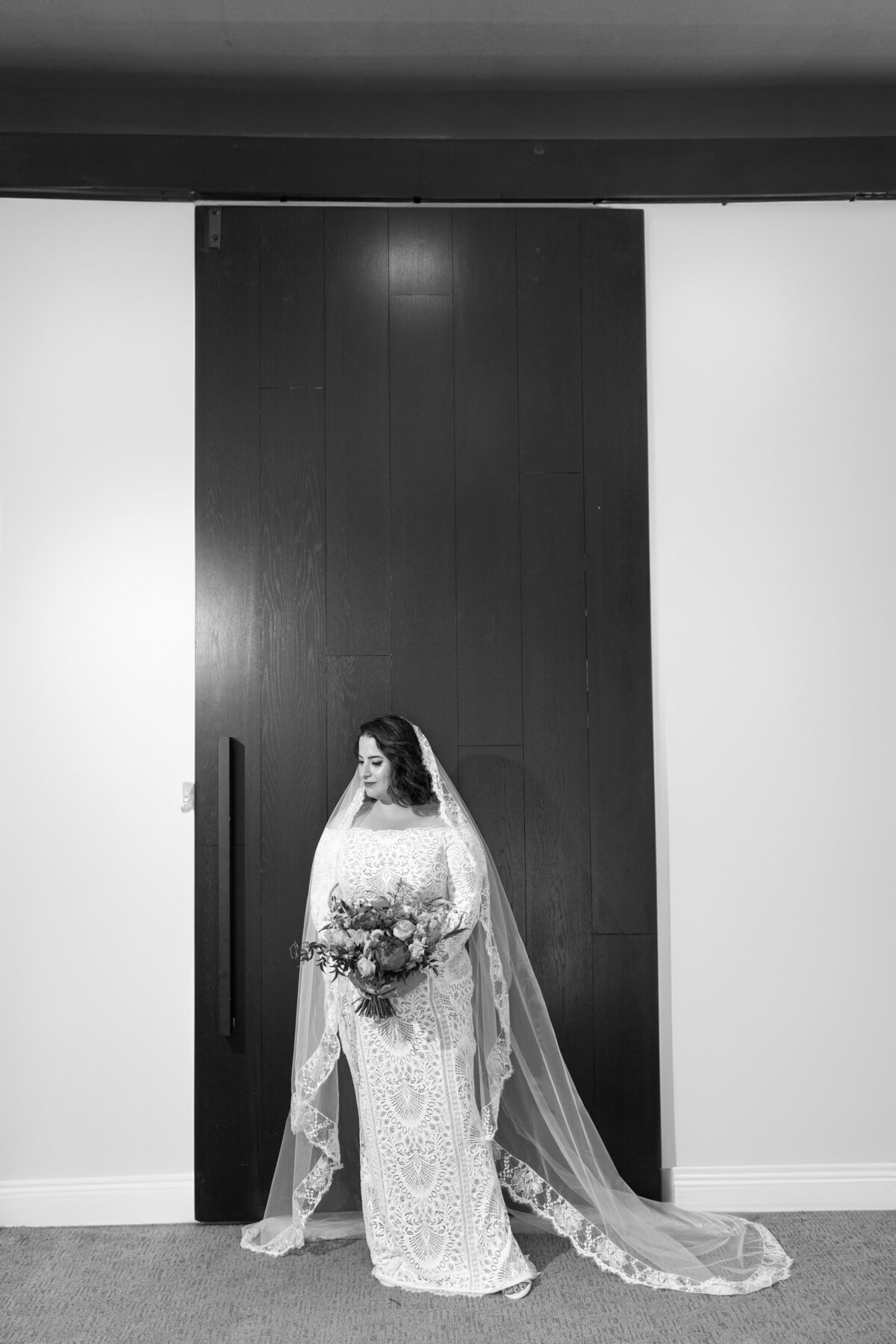 Black and white photo of a bride holding a bouquet of flowers