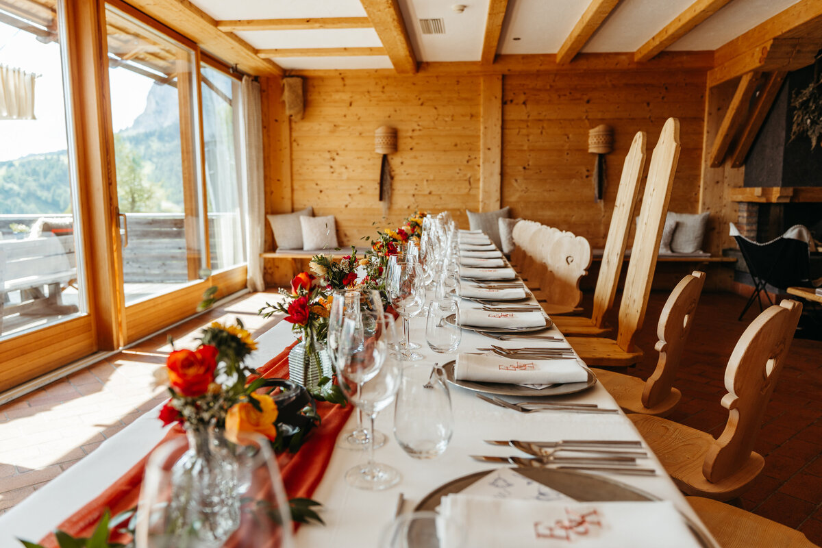 Elegant dinner table setup with red and gold accents Dolomites wedding