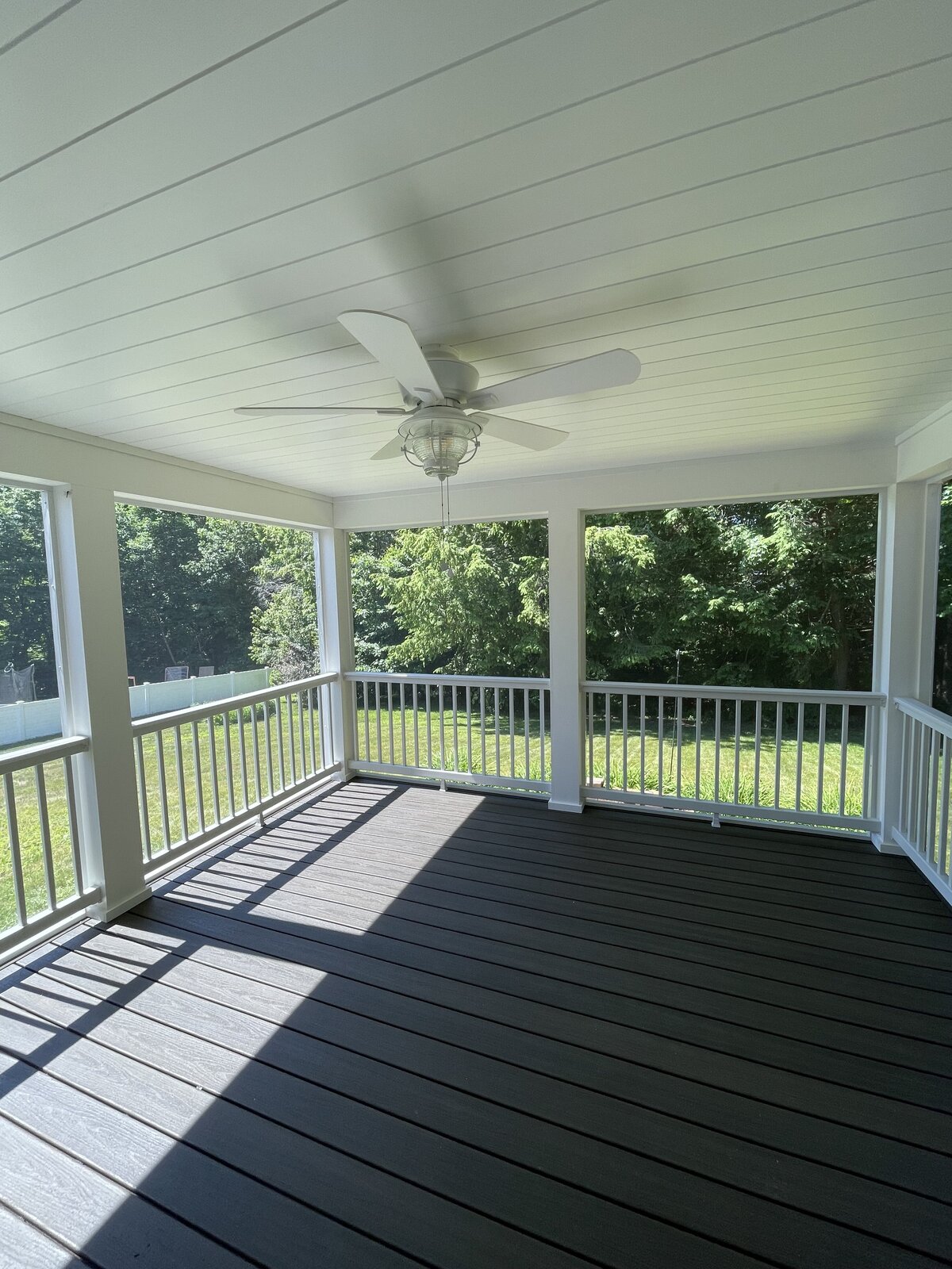 A View Of An Open Porch With Grey composite and lighting built in