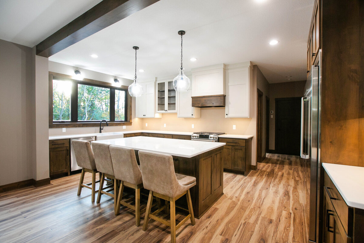Open kitchen with dark cabinets, large island, and quartz countertops in an Big Lake Township custom home
