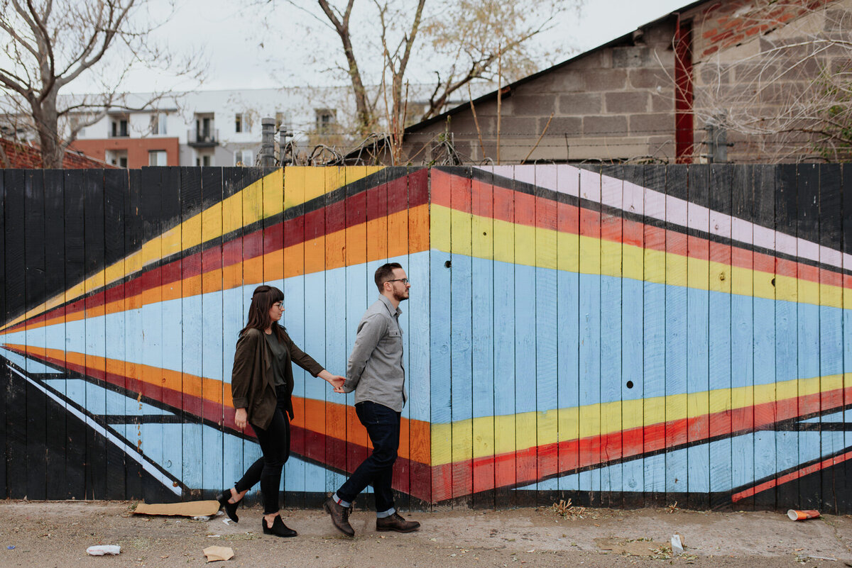 Urban couple walking in front of an art mural in Denver Colorado