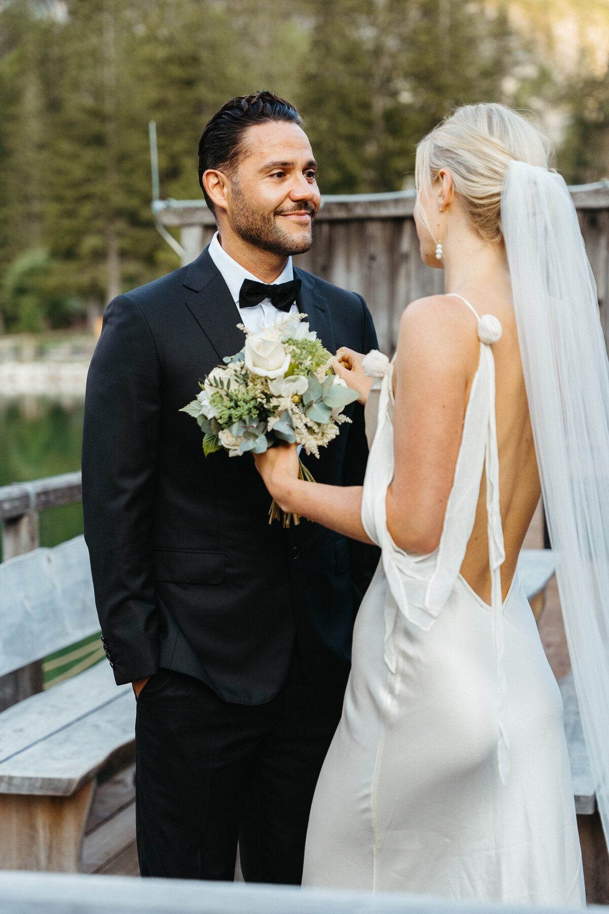 Groom wiping tears during emotional first look with bride