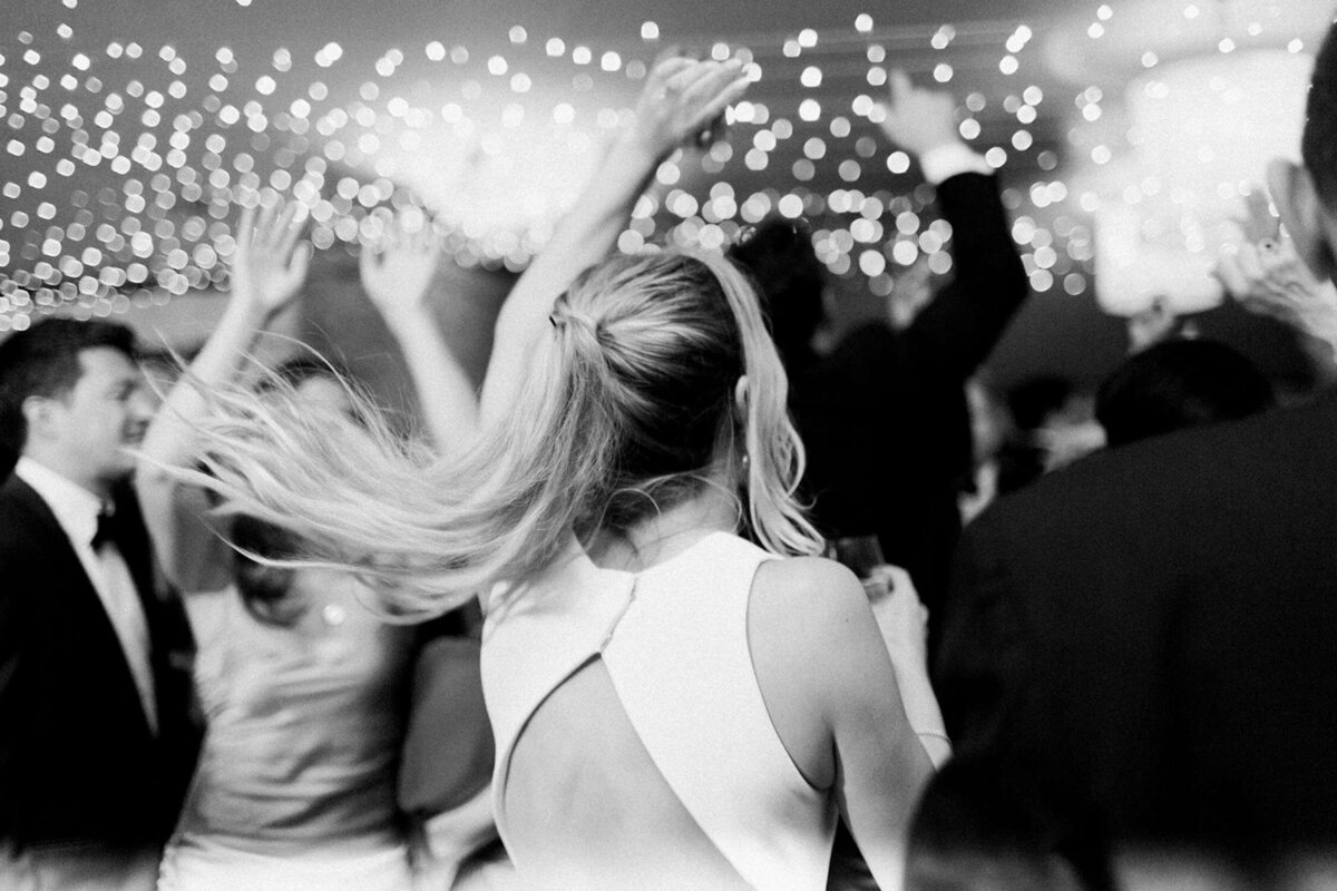 Bride dancing under the soft glow of the string lights in the tent at a luxury Chicago outdoor garden wedding.