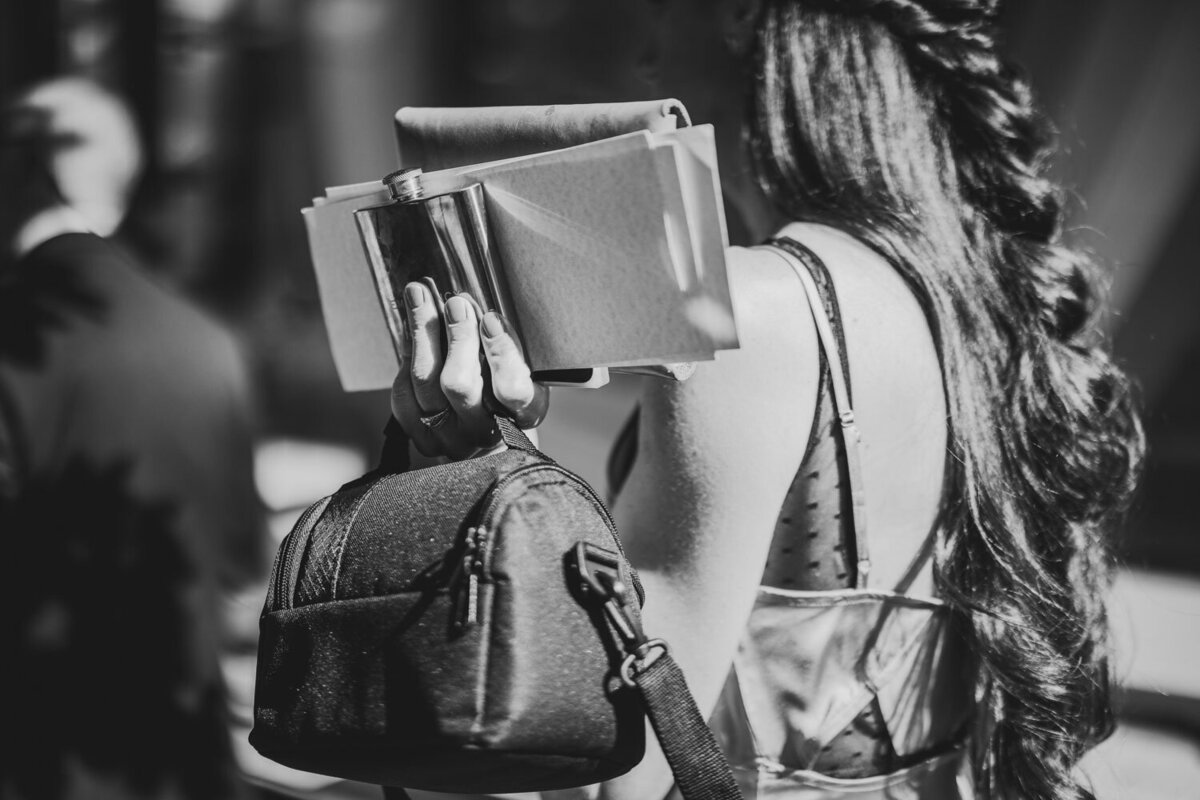 Girl holding her bag, perfume and wallet on single hand