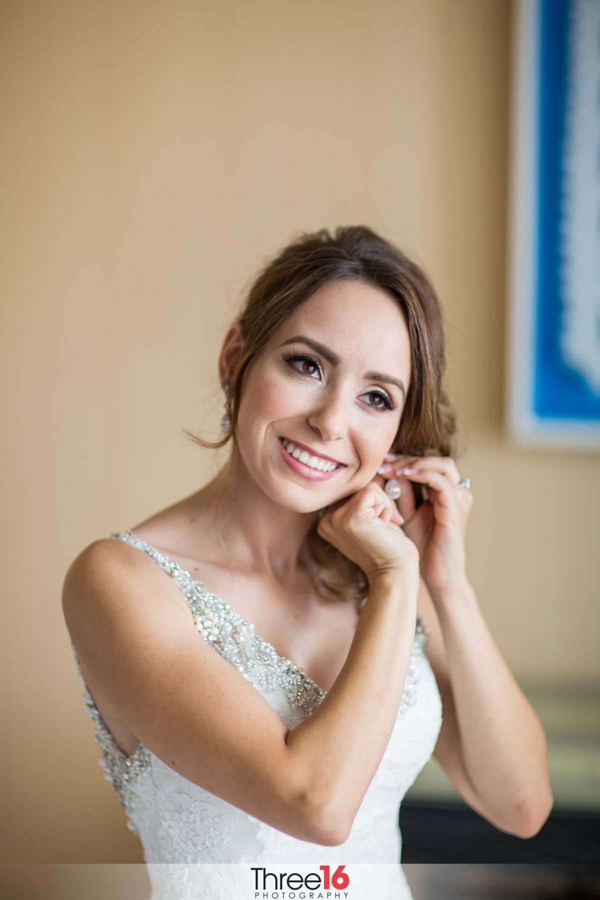Bride putting on her earring as she gets ready for her wedding
