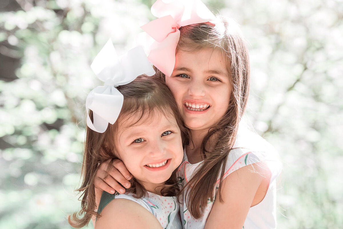 sistes hugging and posing for photographer rosa ashdown