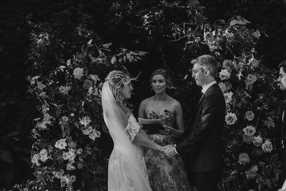 a couple holding hands as they say their vows