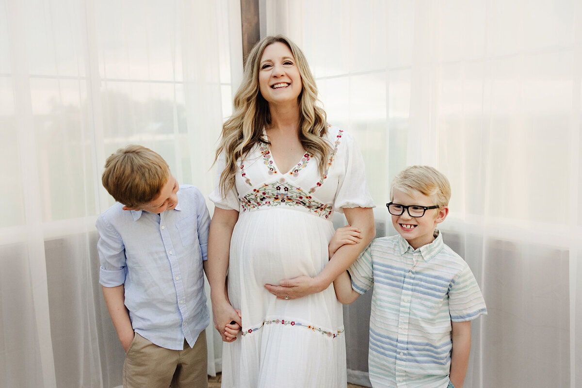 Expecting mom poses with sons