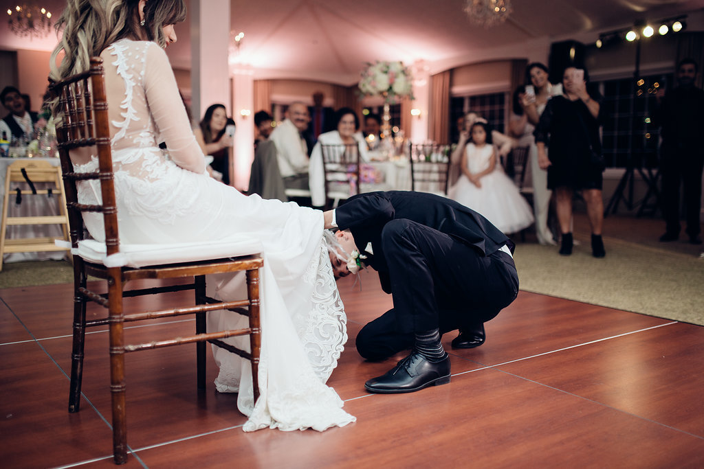 Wedding Photograph Of Groom Removing The Wedding Garter From The Bride Los Angeles