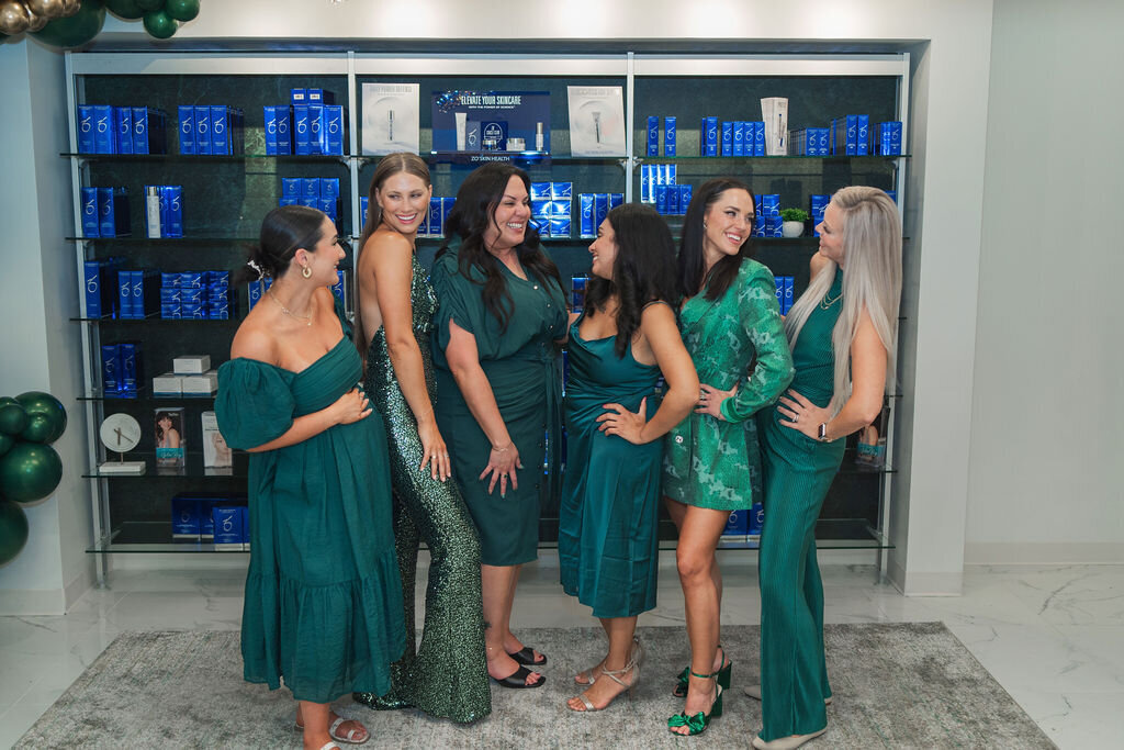 women in green posed at new business opening