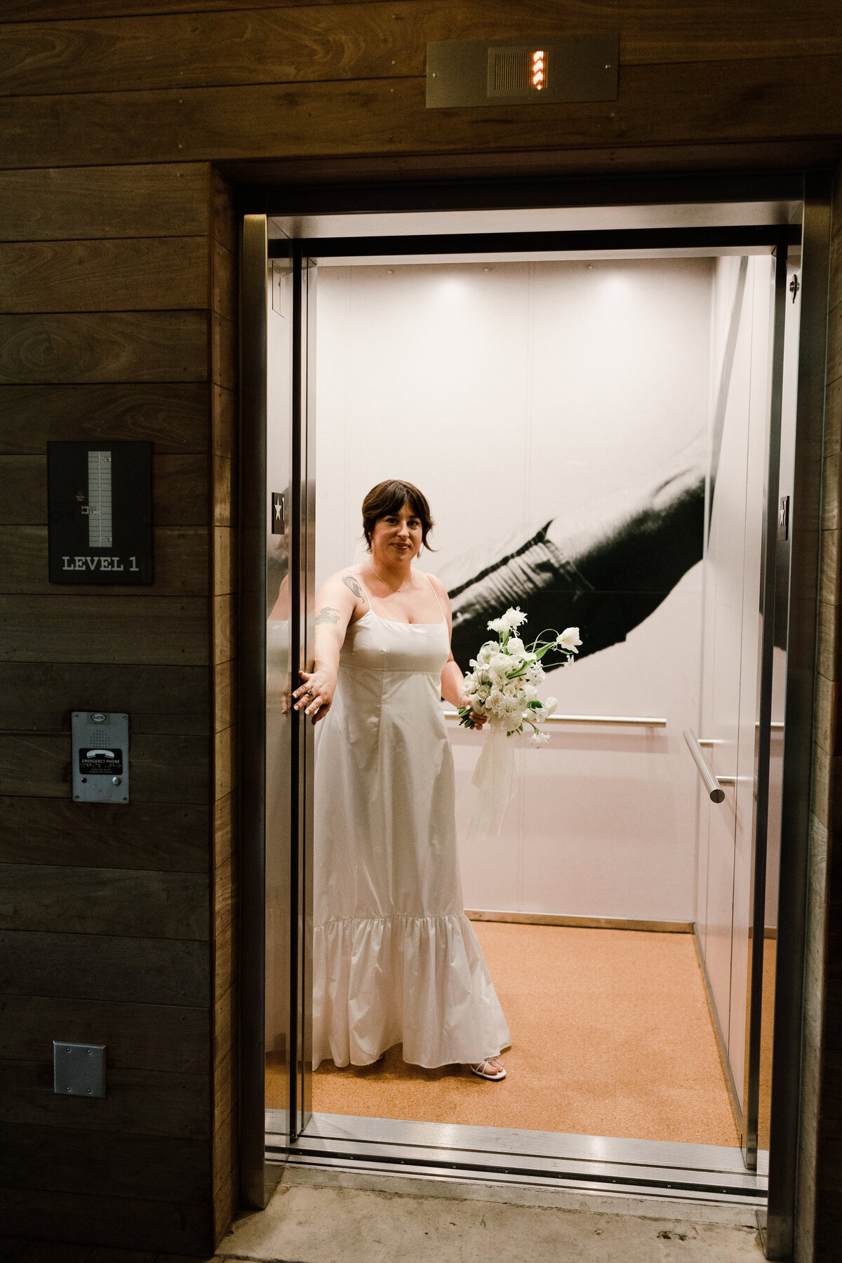 Bride standing in an elevator holding the door open at  Carpenter Hotel, Austin