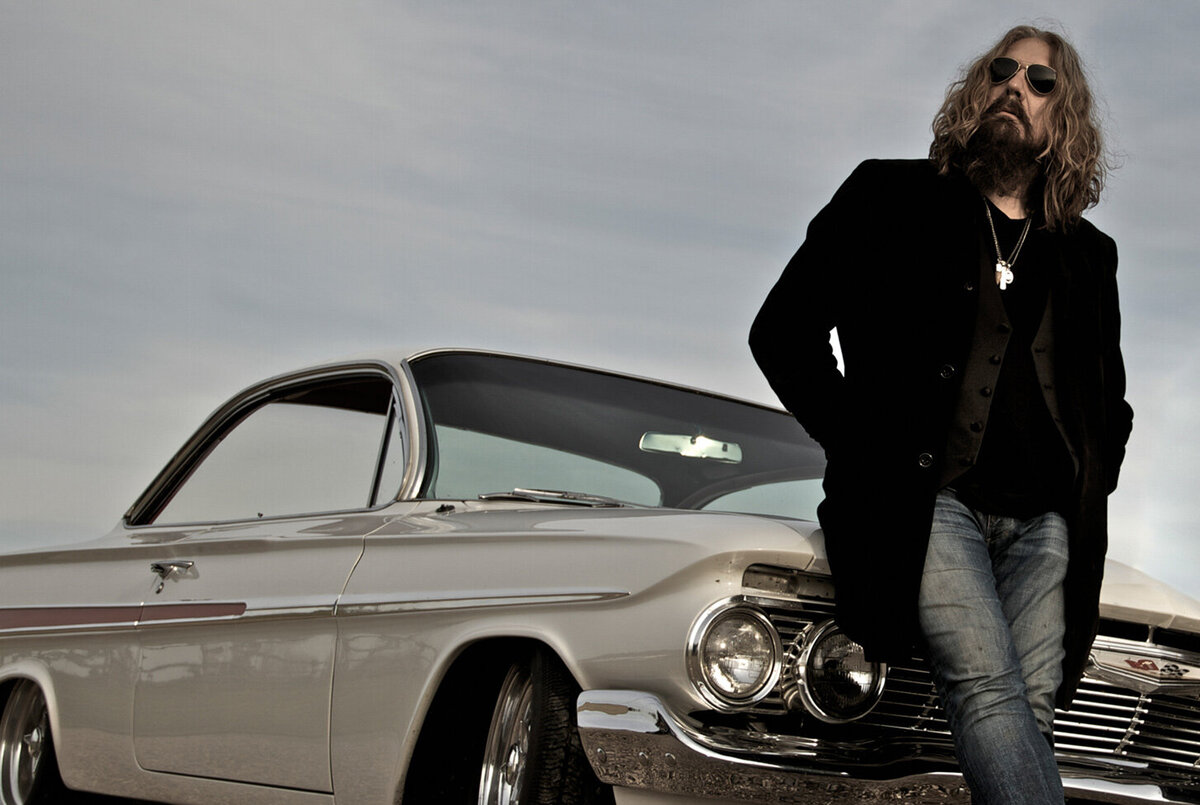 Musician portrait Tom Wilson full length standing in front of vintage white car