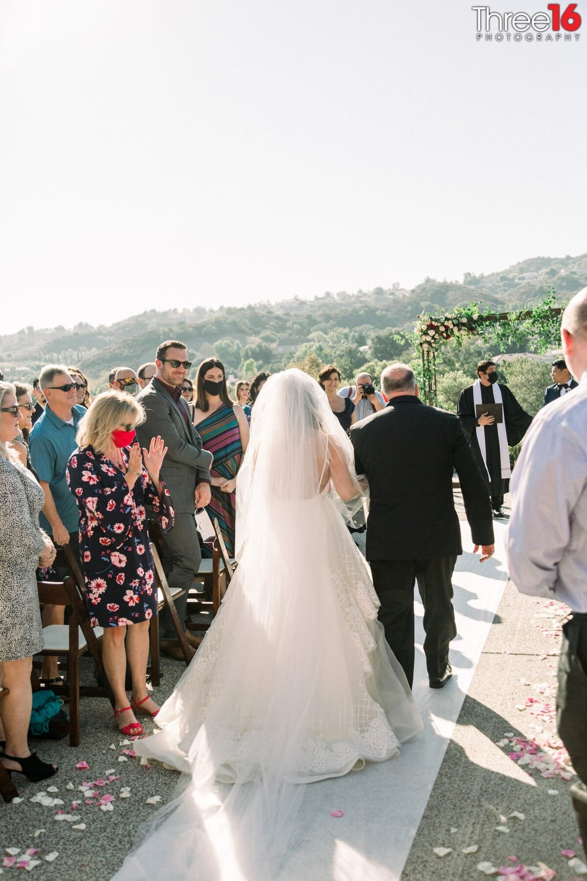 Bride walks towards the altar as she is escorted by her father