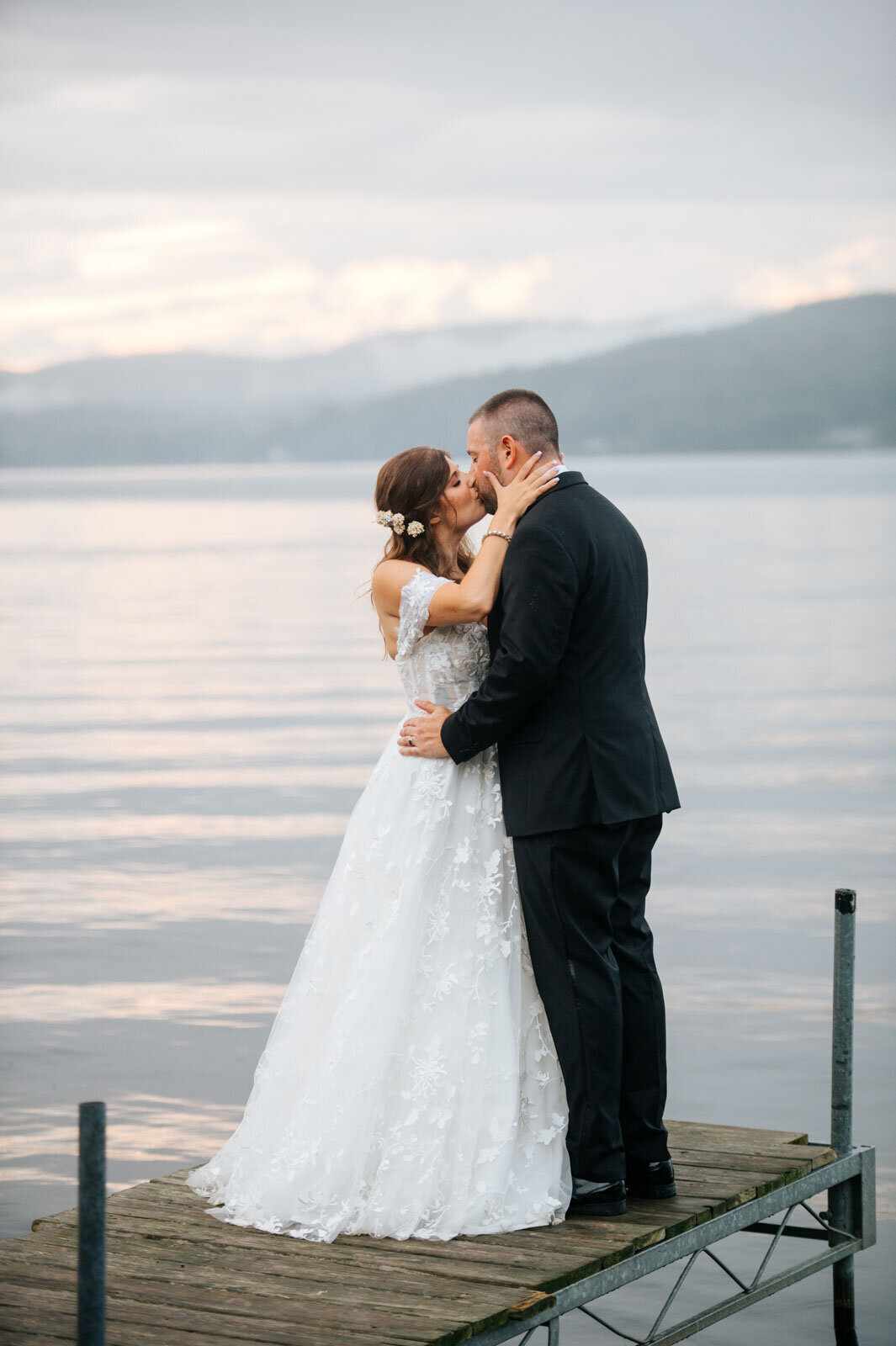 bride and groom kissing on dock at sunset on lake bomoseen wedding vermont