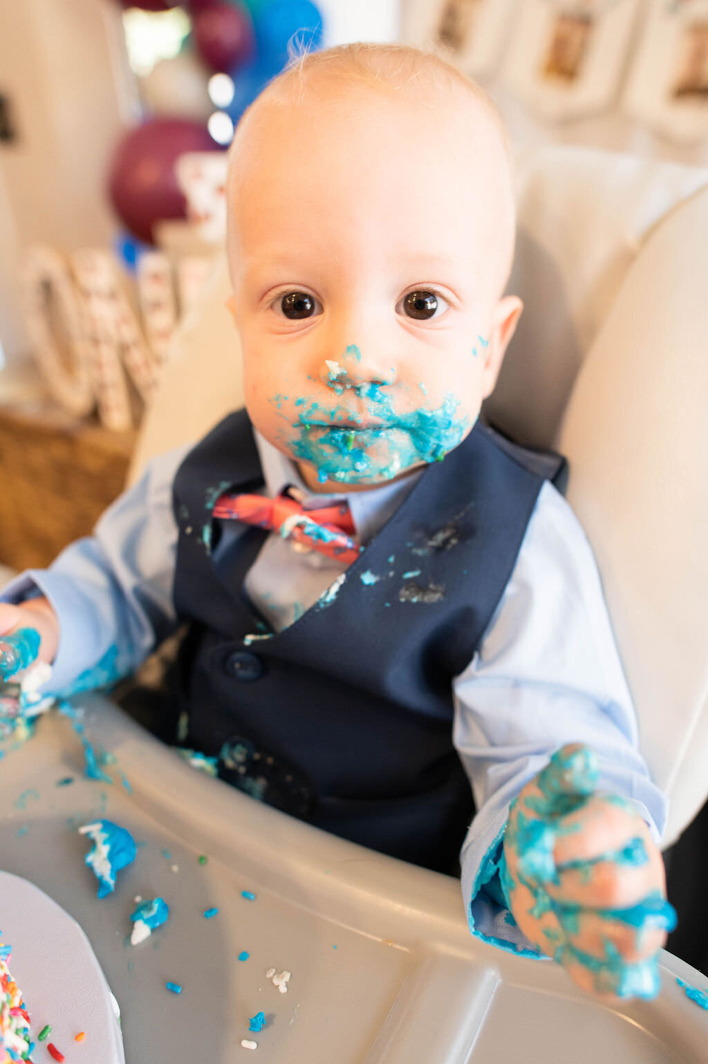 A baby in a suit covered in blue frosting.