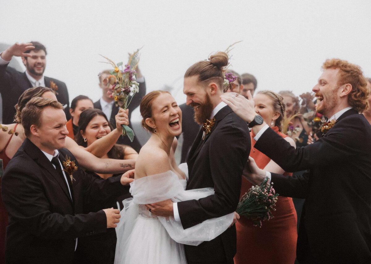 Bride and Groom Surrounded by their friends and laughing