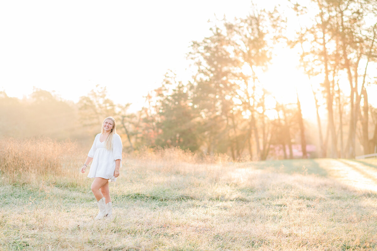 a girl standing in a field on a sunny day