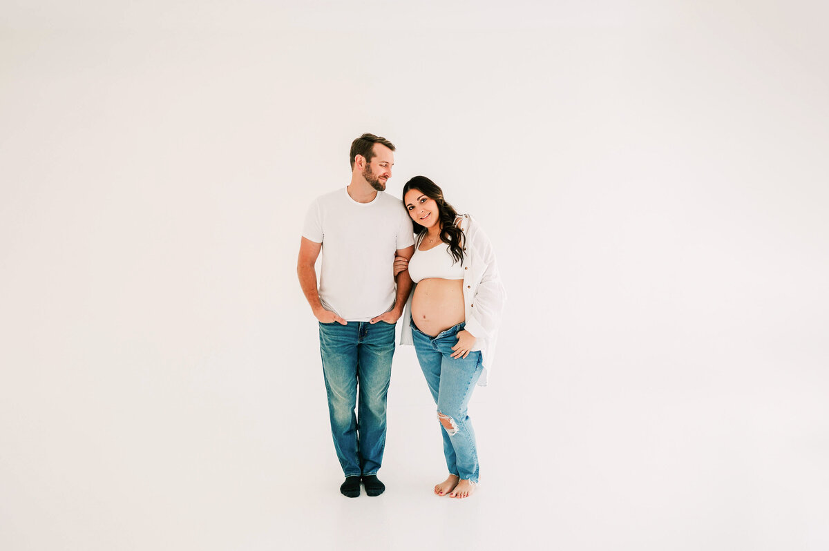 maternity photo in Springfield MO of husband looking at pregnant mom leaning on his shoulder