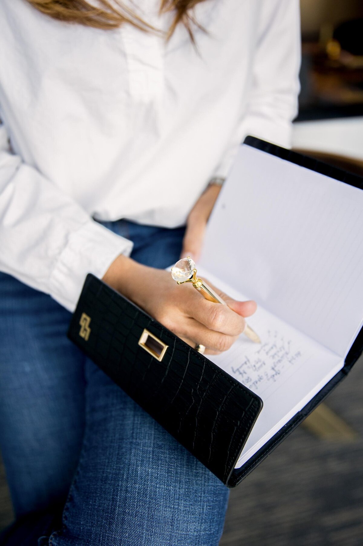 Carolina writing with a pen. Perfect for branding photoshoot ideas focusing on productivity, work habits, and professional focus.
