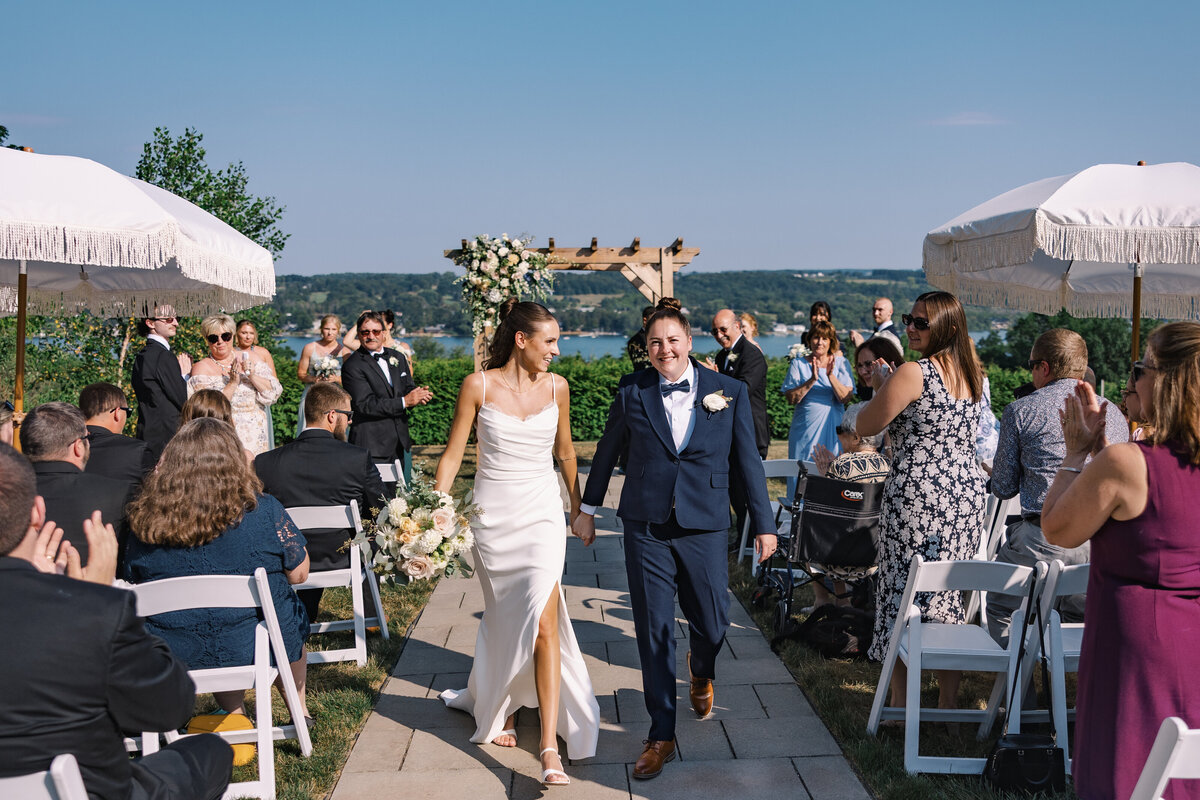 Bride and Bride looking at each other almost kissing under a tree in front of historical building at Cornell University at Crispin Hill