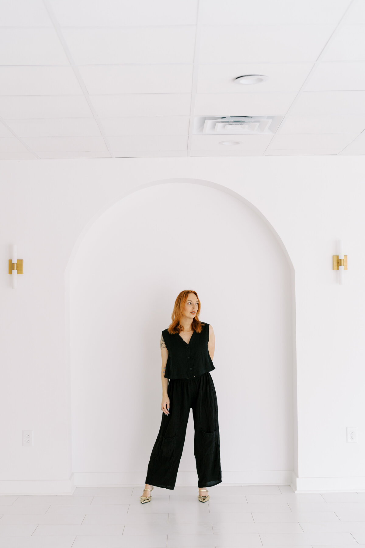 model posting in front of arches