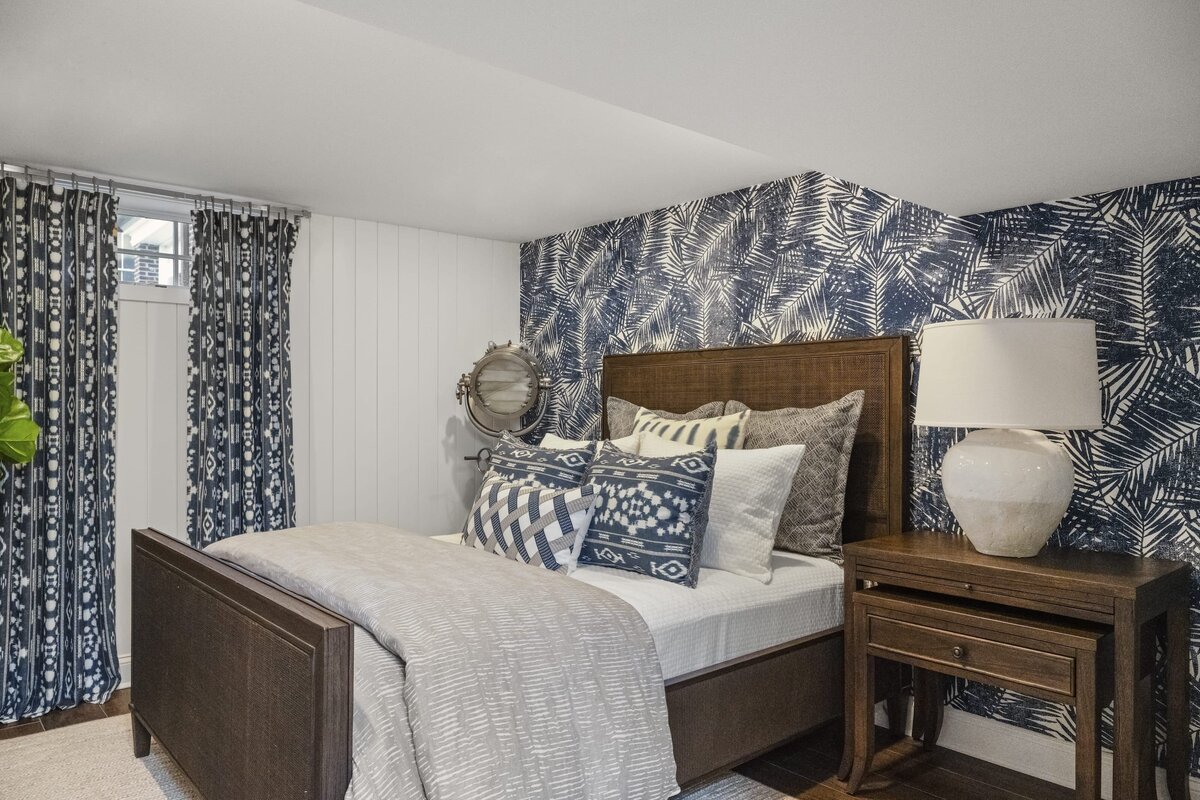 candra lynn interiors ocean port project bedroom with bold wallpaper and curtains with dark wooden bed and sidetable