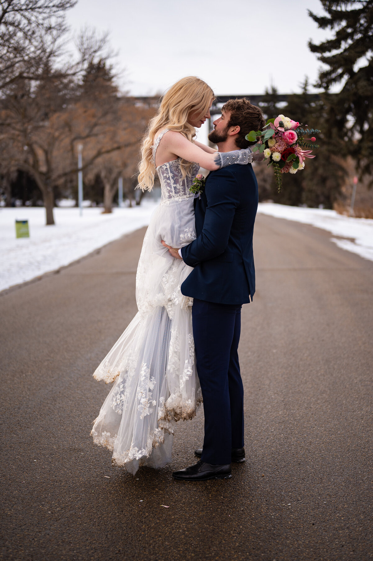 groom picks up his bride and spins her around in celebration