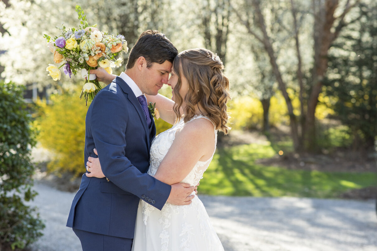 Couple snuggling during wedding photos at Hawkesdene