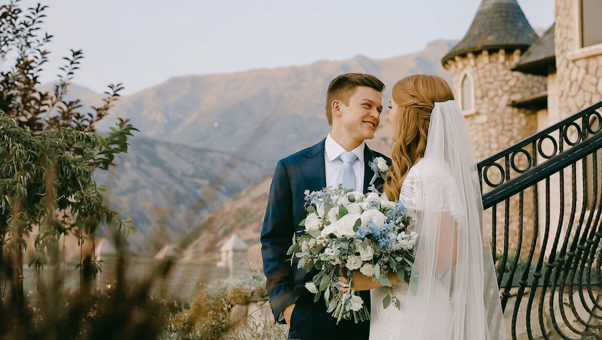 Bride and Groom smiling at each other Wadley Farms Venue with mountains behind castle taken by Cali Warner Media