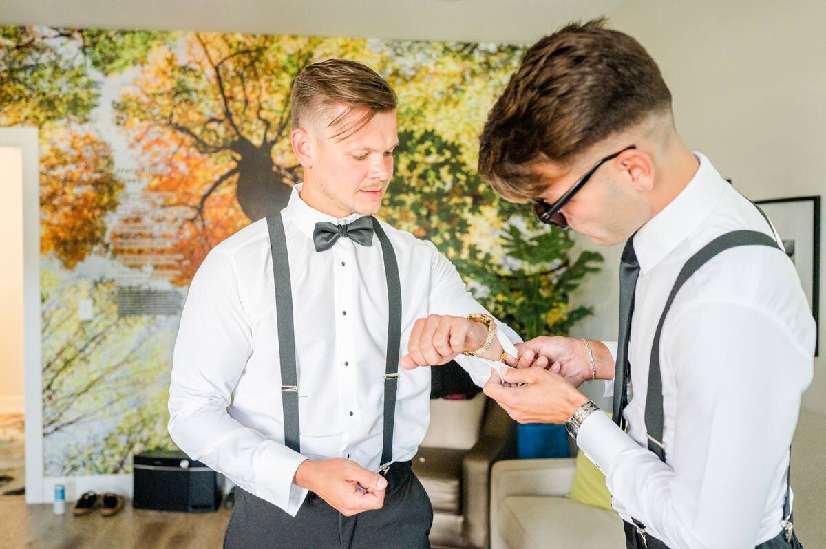 best men puts on grooms cufflinkes