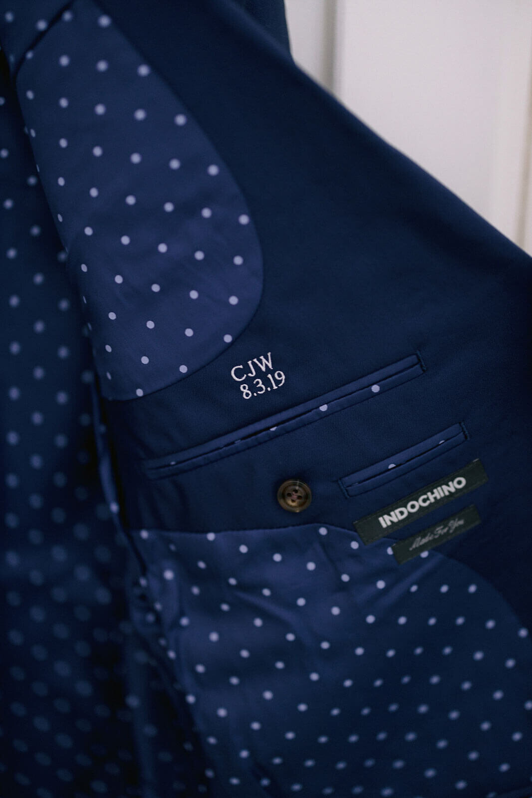 A close-up shot of the groom's suit, showing the brand name, Indochino, at Cape Cod, MA.